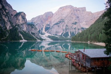 Bries Gölü Panoraması. Göl kenarındaki ahşap ev. Göl dağları yansıtır. Bries Gölü. Lago di Bries 