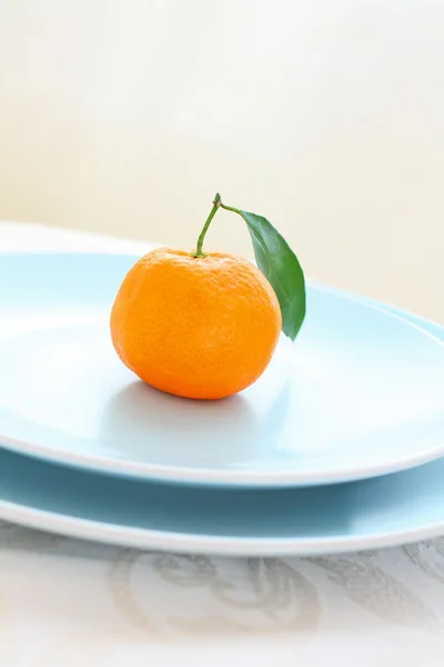 Ripe clementines on the blue, pastel plate — Stock Photo, Image