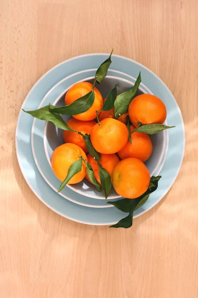 Ripe clementines on the blue, pastel plate — Stock Photo, Image