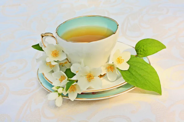 Fleurs de jasmin et une tasse de thé — Photo