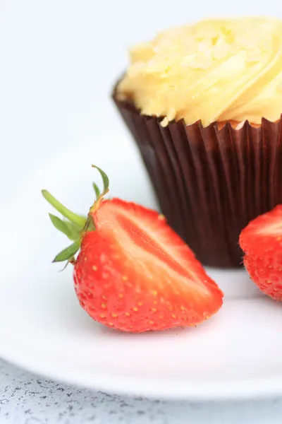 A lemon cake on white plate with strawberries, close up — Stock Photo, Image