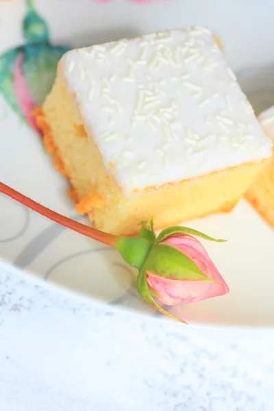 Un pastel fresco con un capullo de rosa, taza de cierre —  Fotos de Stock