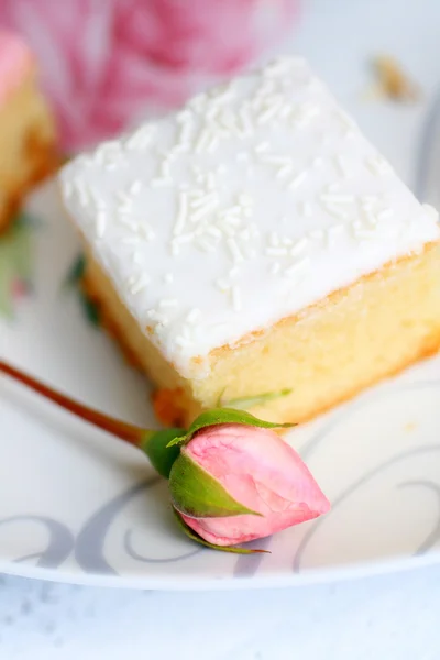 Un pastel fresco con un capullo de rosa, taza de cierre —  Fotos de Stock