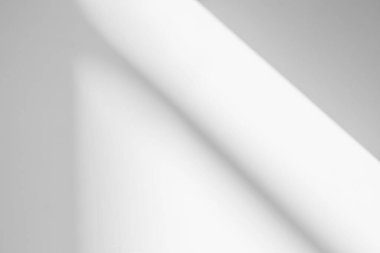 Pencerenin beyaz duvarında gri gölge ve ışık bulanık arkaplan. Mimari çizgiler. Salonun arka planında koyu gölgeler. Monokrom.