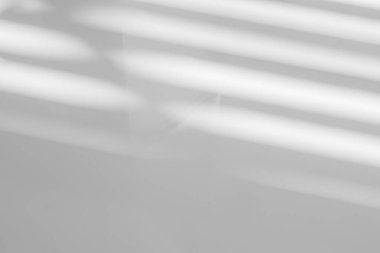 Pencerenin beyaz duvarında gri gölge ve ışık bulanık arkaplan. Mimari çizgiler. Salonun arka planında koyu gölgeler. Monokrom, gölge örtüsü etkisi.