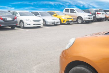 Araba arka arkaya büyük bir asfalt otoparka park edilmiş. Taze ozon ve seyahat teknolojisinin yeşil ortamına sahip açık otopark.
