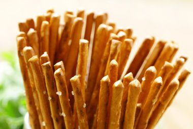 Masanın üzerine bir bardak tuzlu aperatif ekmek sopa