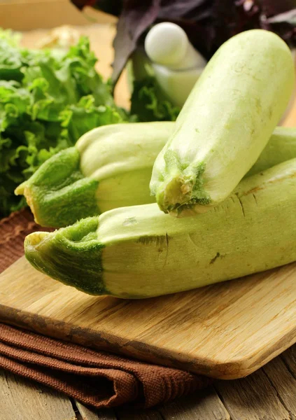 Fresh ripe green zucchini on a wooden board — Stock Photo, Image