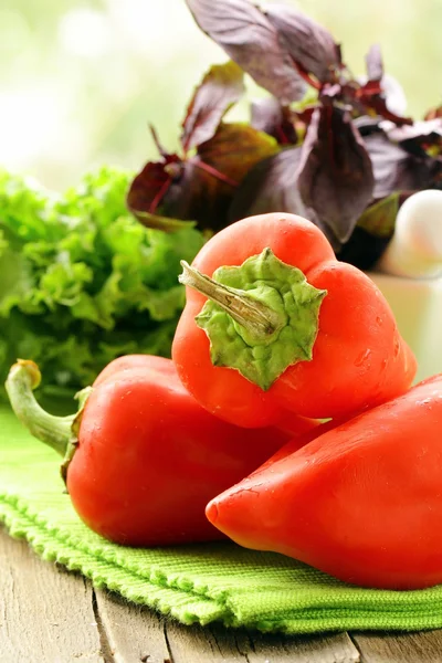 Fresh ripe red bell paprika peppers on a kitchen board — Stock Photo, Image