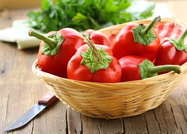 Fresh ripe red bell paprika peppers on a kitchen board — Stock Photo, Image