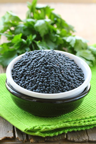 Beluga black lentils in a bowl on a wooden table — Stock Photo, Image