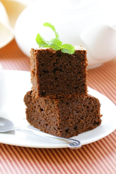 Κέικ σοκολάτας brownie με ένα φύλλο μέντας σε ένα πιάτο — Φωτογραφία Αρχείου