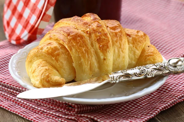 Croissant com engarrafamento em uma chapa - o café da manhã francês — Fotografia de Stock