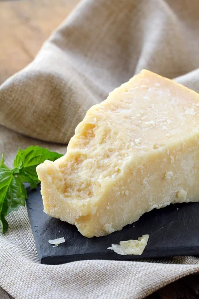Сыр пармезан - твердый итальянский сыр на деревянном столе — стоковое фото