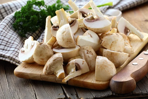 Champiñones de champiñones frescos, rebanados en rodajas en el tablero — Foto de Stock