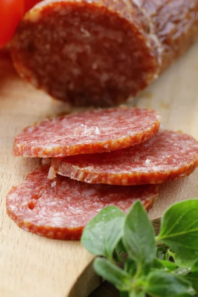 Pokrojone mięso kiełbasa salami na desce z zielony zioła — Zdjęcie stockowe