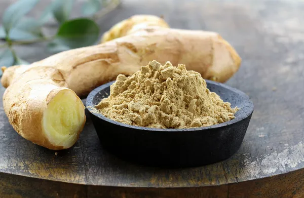 Ground ginger (spice) and fresh on a wooden board — Stock Photo, Image