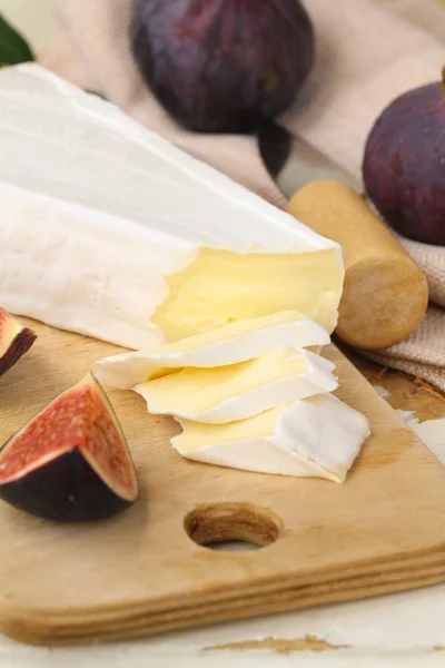 Brie cheese and sweet fruit figs on a wooden board — Stock Photo, Image