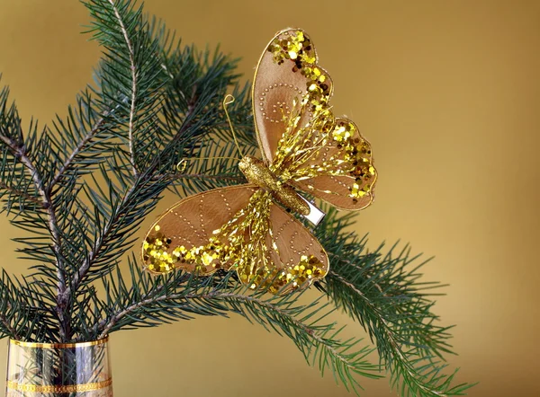 Рождественское украшение (золотая бабочка) на ветвях ели — стоковое фото