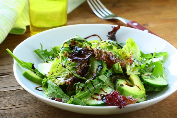 Mélange de salade avec avocat et concombre, avec vinaigrette balsamique — Photo