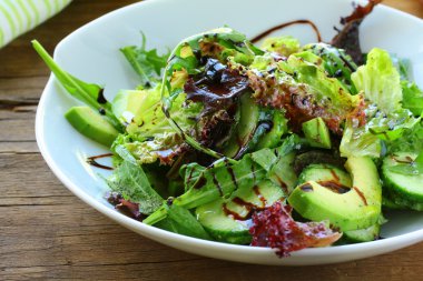 Salad mix with avocado and cucumber, with balsamic dressing clipart