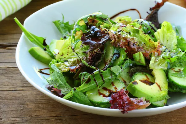 Mezcla de ensalada con aguacate y pepino, con aderezo balsámico — Foto de Stock