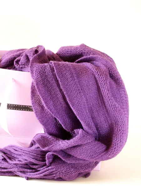 Warm knitted purple scarf in a paper bag — Stock Photo, Image