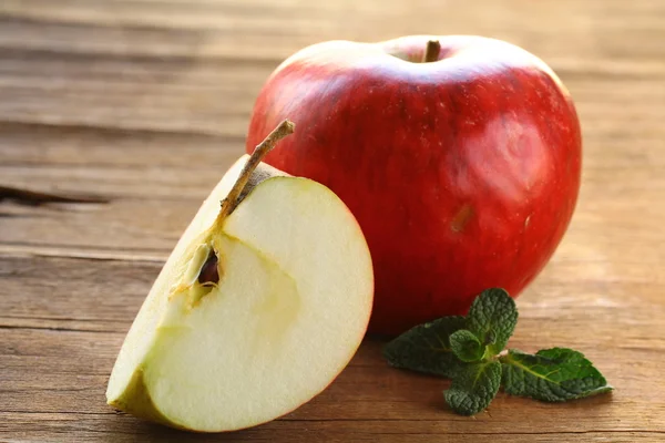 Reife rote Äpfel auf einem Holzbrett geschnitten — Stockfoto