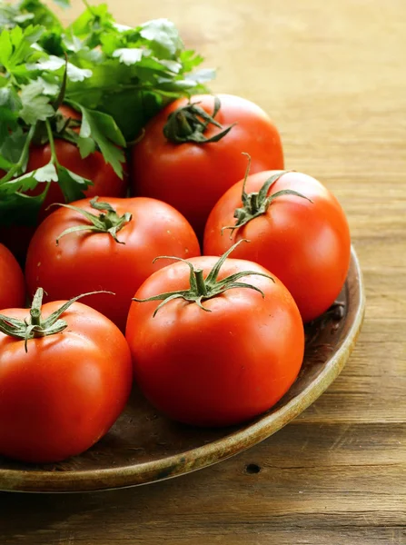 Ripe organic tomatoes on a wooden table — Stock Photo, Image