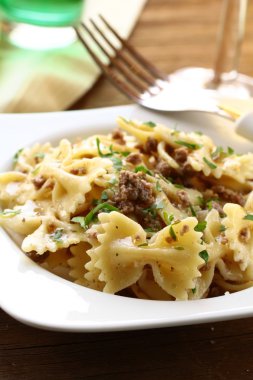 Farfalle pasta with beef sauce on plate with fork clipart
