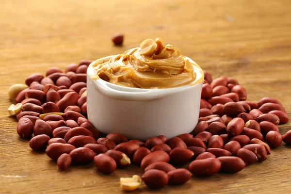 Арахисовое масло и орехи на столе — стоковое фото