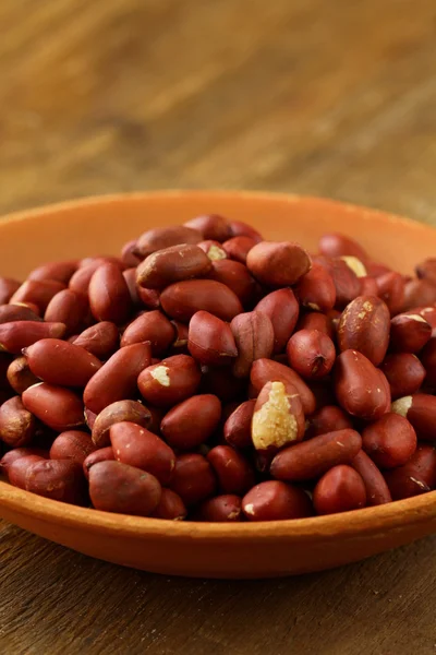 Ahşap bir masa üzerinde bir bardak fıstık tedavi — Stok fotoğraf