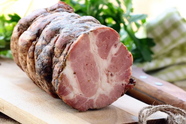 Porco de rolo de carne em uma tábua de corte de madeira — Fotografia de Stock