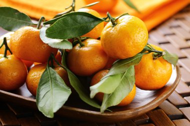 Olgun sulu mandalina, portakal mandalina ile tahta masada bırakır.