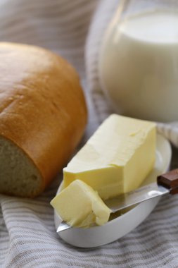 Tereyağ, beyaz ekmek ve süt ahşap plaka üzerinde