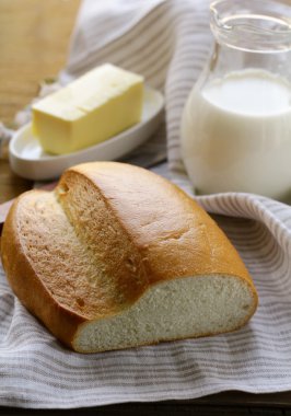 Tereyağ, beyaz ekmek ve süt ahşap plaka üzerinde