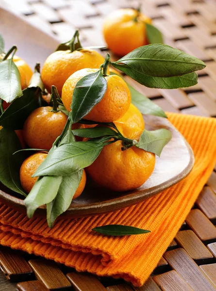 Reife saftige Mandarine, orange Mandarine mit Blättern auf Holztisch — Stockfoto