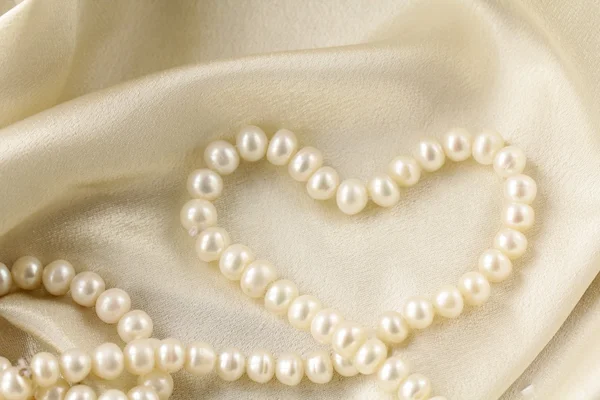 Collana di perle a forma di cuore su tessuto di seta — Foto Stock