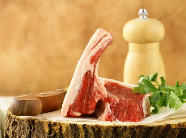 Carne cruda, costolette di agnello su un tagliere di legno — Foto Stock
