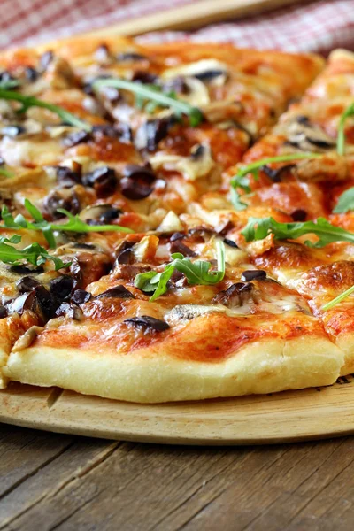 Pizza italiana con funghi e olive su una tavola di legno — Foto Stock