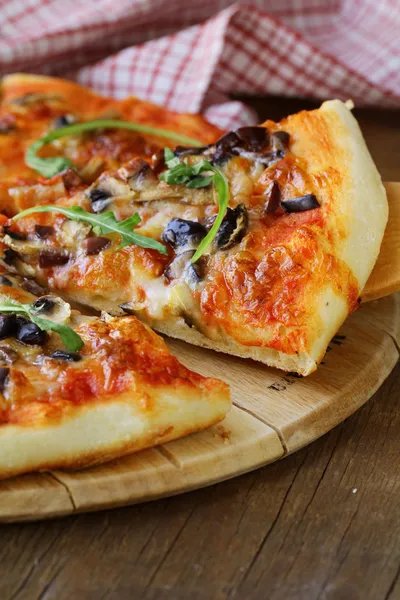 Pizza italiana con funghi e olive su una tavola di legno — Foto Stock