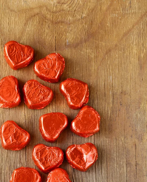 Chocolats en forme de coeur sur un fond en bois — Photo