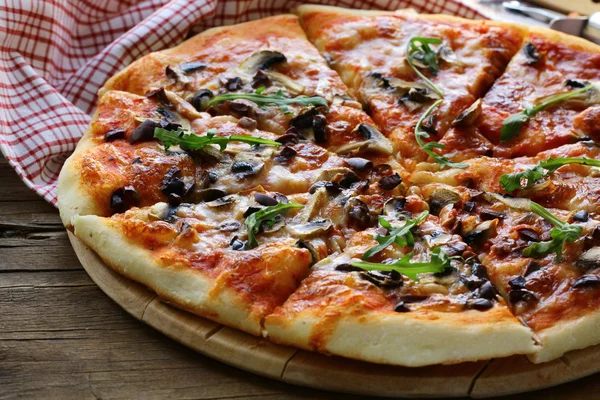 Pizza italiana con funghi e olive su una tavola di legno — Foto Stock