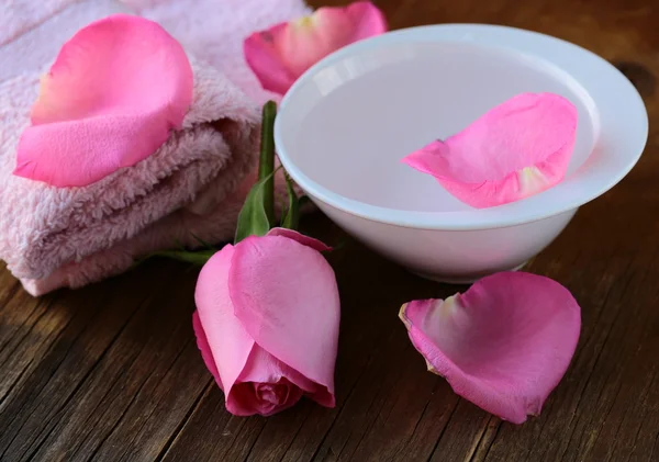 Concepto de spa con pétalos de rosa sobre fondo de madera — Foto de Stock