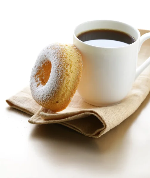 Fresh donut sprinkled with powdered sugar and cup of coffee — Stock Photo, Image