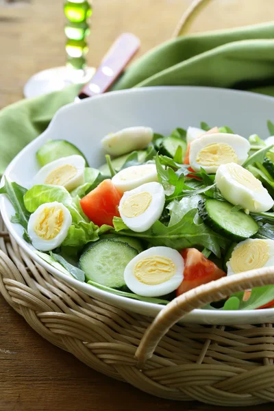 Салат с перепелиными яйцами и помидорами на тарелке — стоковое фото