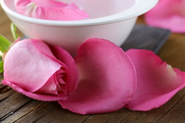 Concepto de spa con pétalos de rosa sobre fondo de madera —  Fotos de Stock