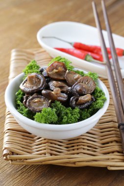 Chinese fried shiitake mushrooms in a bowl with parsley clipart