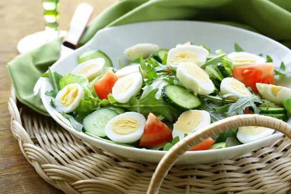 Salade met kwarteleitjes en tomaat op een plaat — Stockfoto