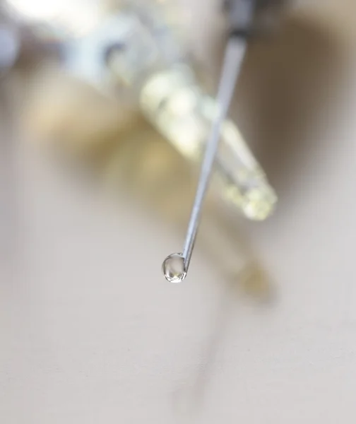 Close-up of vaccine drop on syringe needle — Stock Photo, Image